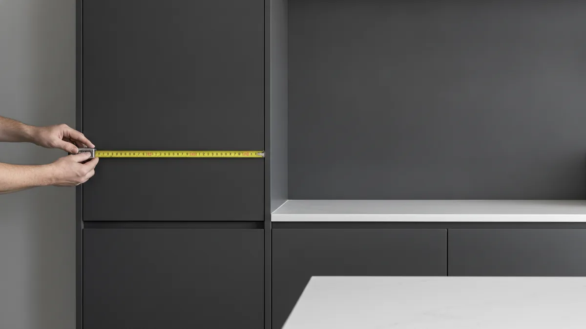 Detail work for cabinet fit Cabinet spacing measurement during kitchen installation planning